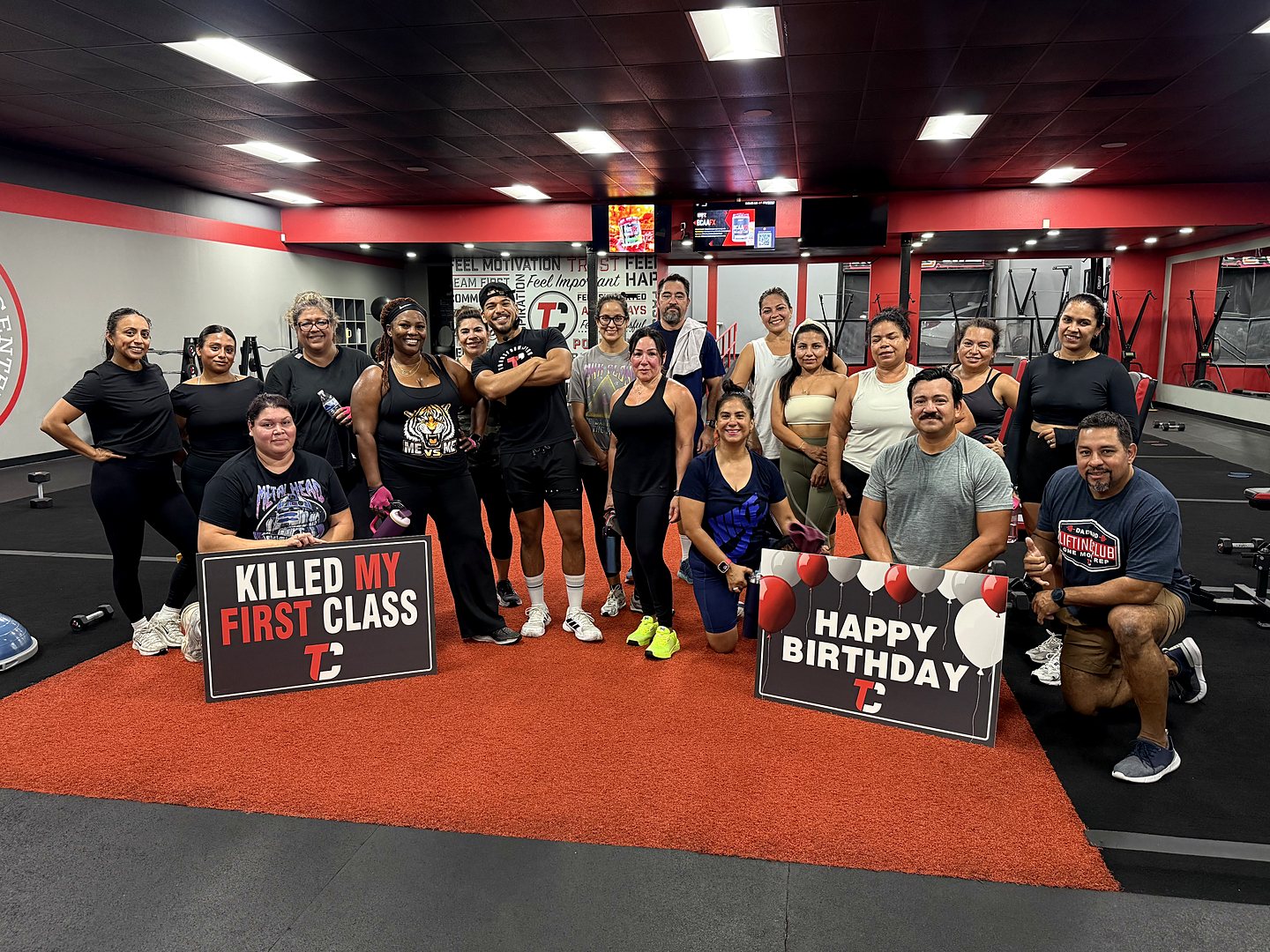 A large Camp Whittier class on the red turf, holding &ldquo;Killed my first class&rdquo; and &ldquo;Happy Birthday&rdquo; signs.