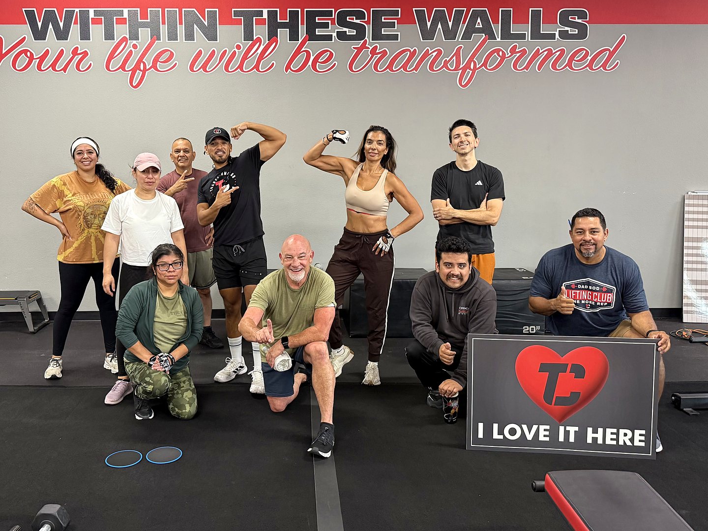 Camp Whittier members flexing under the &ldquo;Within these walls&rdquo; mural, one holding an &ldquo;I love it here&rdquo; sign.